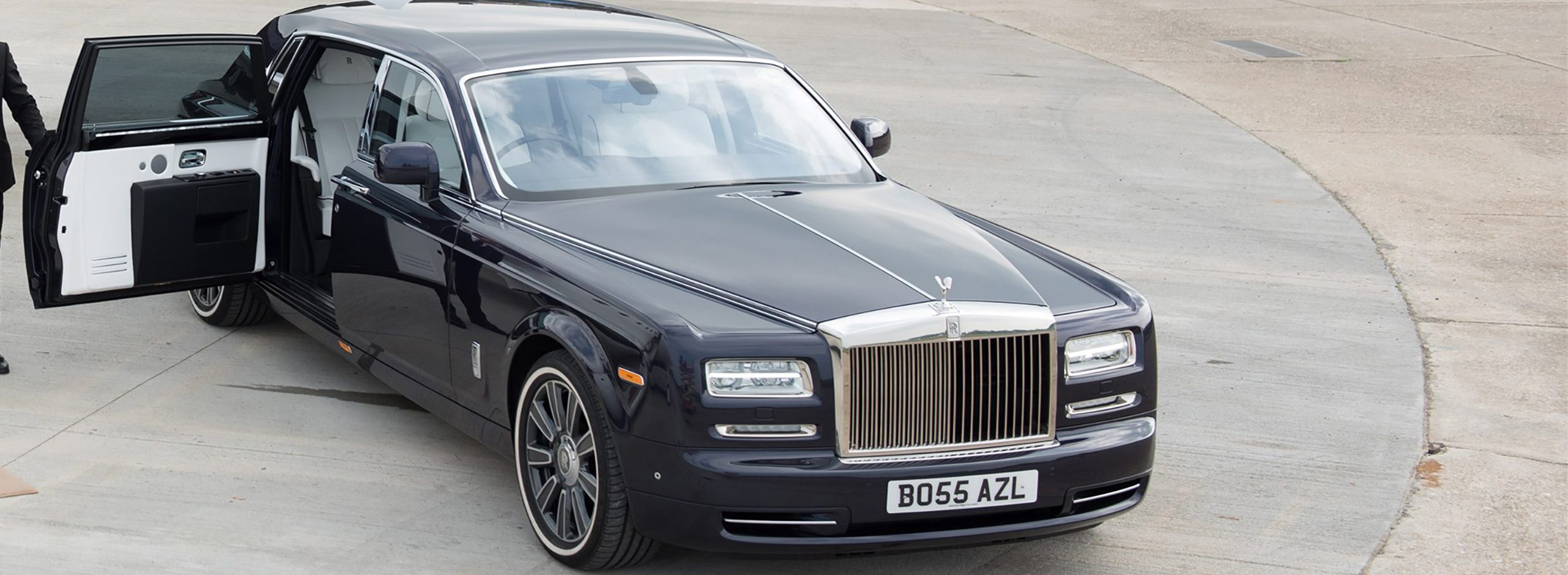 AZ Luxe chauffeur opening door of dark indigo Rolls Royce Phantom for customer