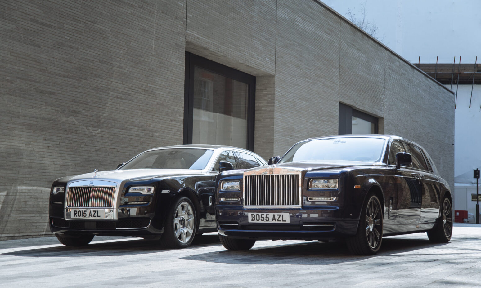 AZ Luxe's two Rolls Royce chauffeur cars: black Ghost and dark indigo Phantom