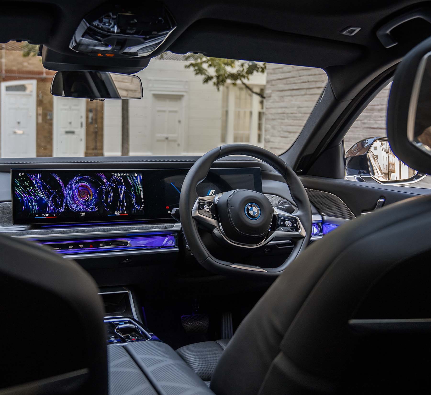 Advanced driver's seat of AZ Luxe's BMW i7, featuring cutting-edge technology controls and steering wheel