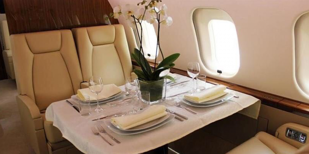 Luxurious interior of a private jet chartered by AZ Luxe, featuring elegant dining facilities and plush seating